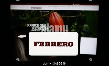 Germania. 10 marzo 2025. In questa foto, una persona ha in mano un cellulare con il logo della società italiana Ferrero International S.A. sullo schermo davanti alla pagina web. (Immagine di credito: © Timon Schneider/SOPA Images via ZUMA Press Wire) SOLO PER USO EDITORIALE! Non per USO commerciale! Foto Stock