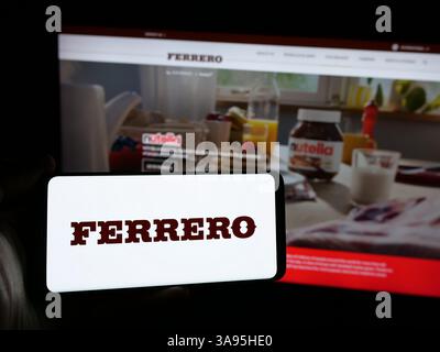 Germania. 10 marzo 2025. In questa immagine, una persona ha in mano uno smartphone con il logo dell'azienda italiana Ferrero International S.A. sullo schermo di fronte al sito Web. (Foto di Timon Schneider/SOPA Images/Sipa USA) *** esclusivamente per notizie editoriali **** credito: SIPA USA/Alamy Live News Foto Stock