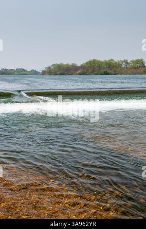 Il potere della natura: Le rapide schiumose che si schiantano contro le antiche formazioni rocciose: L'energia senza domata del Wild River Foto Stock