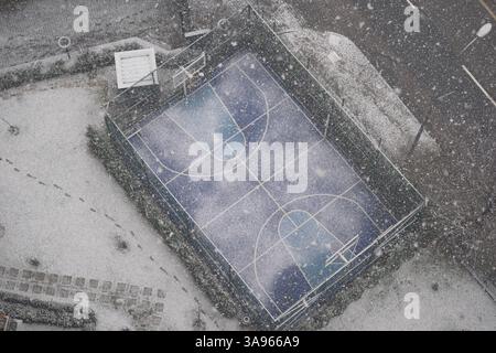Campo da pallacanestro coperto di neve in inverno Foto Stock