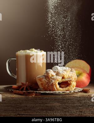Strudel viennese e caffe' latte su un vecchio tavolo di legno. Pasta fresca con anice e cannella cosparse di zucchero a velo. Foto Stock