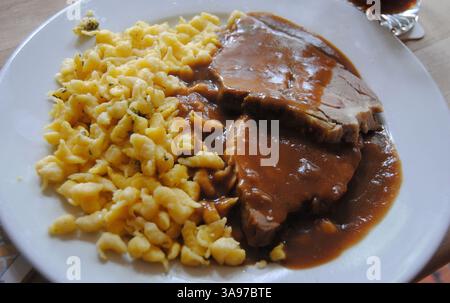 Arrosto di maiale alla birra con salsa di birra scura e spatola Foto Stock