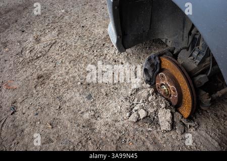 Rusty hub di un'auto abbandonata. Passaruota visibili di un'auto grigia. Foto scattate in condizioni di luce naturale. Foto Stock
