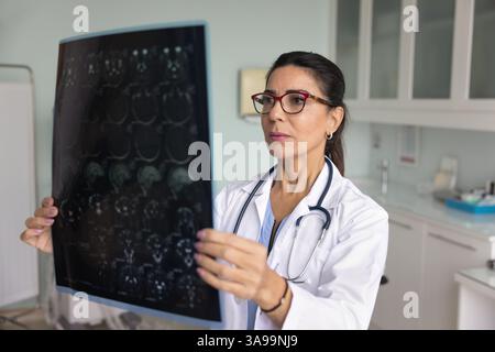 Neurologo senior specializzata medico donna che studia risultati degli esami di radiologia Foto Stock