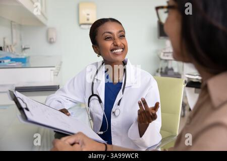 Allegra giovane medico africano che parla con una donna matura Foto Stock