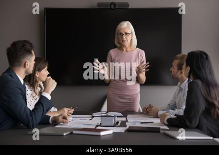 Una relatrice femminile, leader del team di mezza età, è sicura di sé Foto Stock