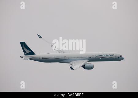 Volo speciale Cathay Pacific CX8100 (Airbus 350-1000) che vola in basso attraverso il porto per celebrare il 100° anniversario dell'aeroporto di Kai Tak (1925-1998) Foto Stock