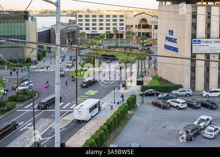 New Orleans, Louisiana USA 28 febbraio 2025 la motocicletta della polizia Harley Davidson si è fermata in un incrocio, persone che camminano, palo leggero, cartello P, limousine, VIP Foto Stock