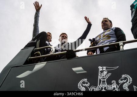 Il capo-allenatore del Newcastle United Eddie Howe (a destra) e l'allenatore Graeme Jones (a sinistra) salutano i tifosi riuniti sabato 29 marzo, diverse centinaia di migliaia di tifosi del Newcastle United fiancheggiano le strade del centro città per dare il benvenuto a una sfilata di autobus aperti della squadra vincitrice della Carabao League Cup. La vittoria fu il primo trofeo nazionale del club in 70 anni, e alla celebrazione doveva partecipare un pubblico caotico, rumoroso e adorante. La folla si è riunita la mattina presto in attesa che la squadra passasse dal St. James' Park durante il tragitto attraverso la città fino al Town Moor, dove un evento di celebrazione è continuato fino al Foto Stock