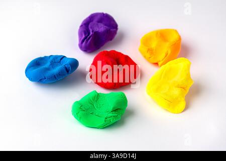 Colorate creazioni di argilla disposte in un design divertente su sfondo bianco Foto Stock
