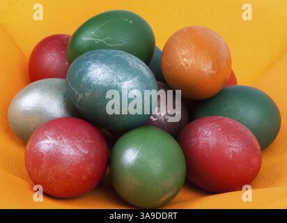 Pasqua uovo tinto messo dal mucchio sul tovagliolo arancio Foto Stock