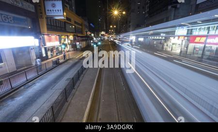 Strada notturna di Hong Kong con sentiero che parte dalla funivia a due piani. Girato in movimento Foto Stock