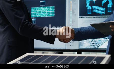 Il responsabile della fabbrica dà il benvenuto all'azionista, stringendo la mano, lavorando insieme per espandere la produzione di impianti industriali. Uomo che fa una stretta di mano con un investitore, sviluppa un modello di business, fotocamera B Foto Stock