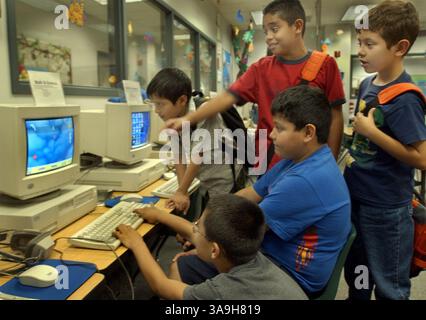 Un gruppo di studenti di quarta e quinta classe gioca un gioco per computer dopo lezione presso il Puente Learning Center giovedì 18 luglio 2002. Il centro non-profit di Boyle Heights si rivolge alla popolazione latina che li circonda nella zona est di Los Angeles. Circa il 87% degli adulti di Boyle Heights non ha conseguito un diploma di scuola superiore. Il centro no-profit è visto come un programma modello per educare i genitori latini su ciò che deve essere fatto per ottenere una laurea ai loro figli. Sacramento Bee/Randy Pench/ZUMA Press Foto Stock