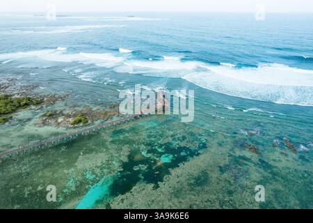 Vista aerea mozzafiato della spiaggia Cloud 9 a Siargao: Una splendida distesa di sabbia bianca, acque turchesi e una passeggiata panoramica in legno sull'Ocea Foto Stock