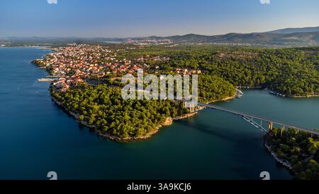 Krapanj, Croazia - Vista aerea del ponte Morinje (Morinjski Most) in una mattinata d'estate soleggiata con la cittadina di Brodarica sullo sfondo con un cielo azzurro Foto Stock