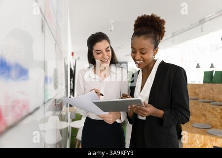 Giovani e diversi amici d'ufficio positivi che lavorano insieme al progetto Foto Stock