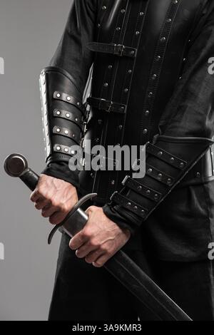 Persona che indossa braccialetti in pelle Black Widow con spade Foto Stock