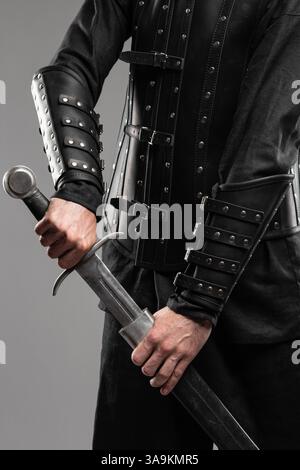 Persona che indossa braccialetti in pelle Black Widow con spade Foto Stock