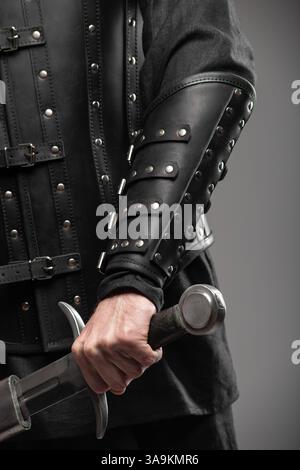 Persona che indossa braccialetti in pelle Black Widow con spade Foto Stock