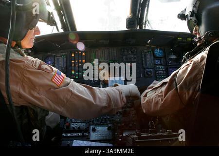 12 marzo 2007 - Balad, IRAQ - Chief Warrant Officers 4 TED WOOLLVEN, 59, di New Braunfels, Right, e BILLY WAYNE BURFEIND, 60, di San Antonio, fanno un'ispezione pre-volo di un elicottero Black Hawk prima di volare una missione VIP a Ramadi dall'area di supporto logistico Anaconda a Balad, Iraq, martedì 13 marzo 2007. Stanno combattendo una guerra a un'età in cui molte persone sono sul campo da golf. Entrambi sono piloti di UH-60 Black Hawk che hanno fatto rapporto alla loro unità della Guardia Nazionale lo stesso giorno dopo aver finito i tour in Vietnam. Più di 35 anni dopo questi migliori amici sono in Iraq insieme nel loro ultimo spiegamento BE Foto Stock