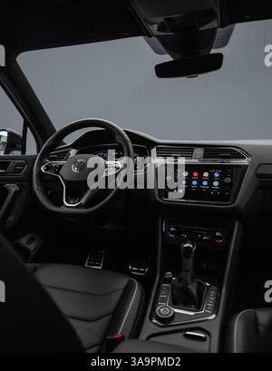Interni Volkswagen Tiguan con dettagli grigio scuro. Volante e cruscotto nella cabina di pilotaggio del SUV tedesco crossover. Foto Stock