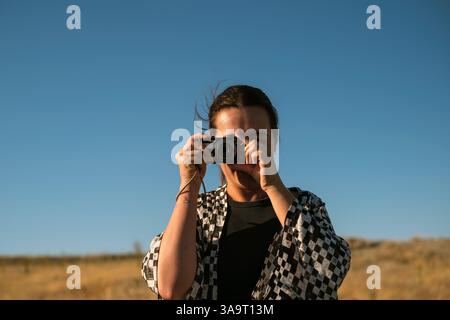 Donna sorridente che tiene una fotocamera digitale in Cappadocia Foto Stock