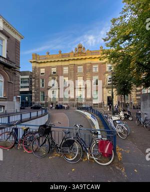 L'Aia, Paesi Bassi - 24 agosto 2024: Edificio storico con architettura classica a l'Aia con colonne e sculture ornate con bicicletta Foto Stock