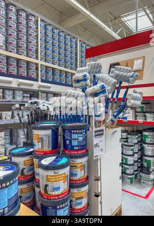 Parigi, Francia - 27 marzo 2025: Un'esposizione di secchi per vernici Dulux impilati e rulli per vernici Dexter è allestita in un corridoio luminoso del negozio di ferramenta, con sh Foto Stock