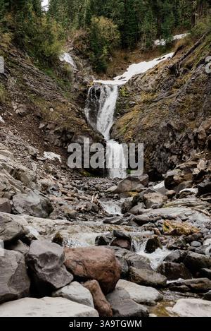 Cascata di montagna che si innalza sulle rocce frastagliate in una remota natura selvaggia Foto Stock