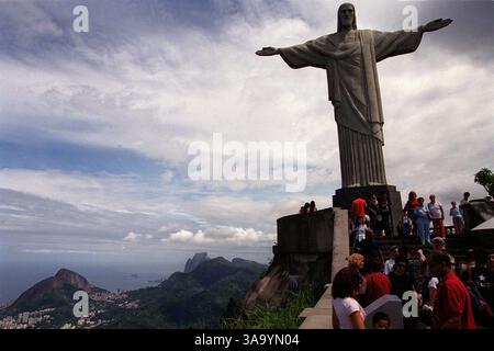 I turisti si aggirano intorno alla base della statua di 100 metri del Cristo Redentore in cima al monte Corcovado del Rio de Janeiero, un blocco di granito che si erge per 2.300 metri nel mezzo della città e offre viste spettacolari da tutte le angolazioni. Sacramento Bee / Walt Wiley aprile 2003 / ZUMA Press Foto Stock