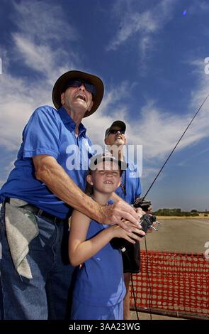 LA FOTO PRINCIPALE Arno Clabaugh (CQ) aiuta Elisha Ingram, 7 anni, a pilotare un aereo RC come presidente del club Jim Vener, giusto, mans i controlli principali. Il Mather Aerospace Modelers Club ha tenuto un Open Field Day, sabato 19 luglio 2003, per presentare al pubblico aerei radiocomandati. Il pubblico ha attraversato tre fasi di apprendimento durante l'evento, la scuola di terra per imparare come vola un aereo, un computer e il volo effettivo di un aereo sotto la guida di un istruttore utilizzando due controller. Il Club conta circa 203 membri e vola su un piccolo campo a Eagles Nest Road e Keifer Blvd. Sacramento Bee/Brian Baer/ZUMA Foto Stock