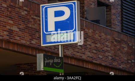 Cartello di parcheggio che mostra i posti disponibili di fronte a un muro di mattoni al supermercato pingo doce in portogallo Foto Stock