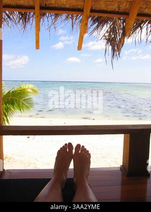 6 maggio 2005; Aitutaki, Isole Cook; l'isola di Aitutaki è un volo di 45 minuti a nord di Rarotonga, l'isola principale delle Isole Cook nel cuore del Pacifico meridionale. Aitutaki è un'isola laguna, con colline ondulate, villaggi pittoreschi e la maggior parte delle sistemazioni turistiche. L'isola è circondata da una barriera corallina e fiancheggiata da una ventina di piccole isole coralline disabitate. Sono queste isole che hanno il fascino più turistico, con splendide spiagge orlate da palme e eccellenti lagune per lo snorkeling. Nella foto: Un bungalow sulla spiaggia presso le ville Etu Moana di Aitutaki. Ma Foto Stock