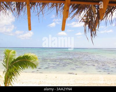 6 maggio 2005; Aitutaki, Isole Cook; l'isola di Aitutaki è un volo di 45 minuti a nord di Rarotonga, l'isola principale delle Isole Cook nel cuore del Pacifico meridionale. Aitutaki è un'isola laguna, con colline ondulate, villaggi pittoreschi e la maggior parte delle sistemazioni turistiche. L'isola è circondata da una barriera corallina e fiancheggiata da una ventina di piccole isole coralline disabitate. Sono queste isole che hanno il fascino più turistico, con splendide spiagge orlate da palme e eccellenti lagune per lo snorkeling. Nella foto: La vista da un bungalow sulla spiaggia dell'Etu Moana Villas i. Foto Stock