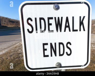La chiarezza e la semplicità del segnale "LATO MARCIAPIEDE" sottolineano silenziosamente la cautela e incoraggiano la curiosità sul percorso da percorrere Foto Stock