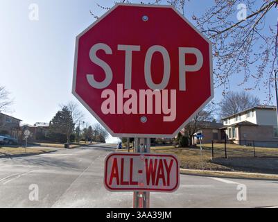 In un tranquillo ambiente periferico, un segnale di stop riflettente ricorda ai passanti la prudenza e la responsabilità della comunità ???? Foto Stock