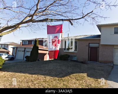 Un perfetto nighborhood. Media casa residenziale con percorso concreto per l'ingresso principale su una lussureggiante cortile anteriore prato Foto Stock