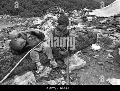 30 gennaio 2007; Ohrid-Resen, MACEDONIA; i bambini dei collezionisti di rottami giocano con qualsiasi giocattolo possano trovare nella discarica di Bukovo. La loro madre ha appena trovato delle scarpe e un sacco di vestiti da indossare. I rom ottengono molti dei loro bisogni di base dalla discarica. I rom della classe media più redditizia dal punto di vista economico si sono ben integrati con la più ampia comunità macedone, vivono negli stessi quartieri, mandano i loro figli nelle stesse scuole e gestiscono le loro attività. La maggior parte dei rom, tuttavia, vive in quartieri distinti. I Rom rimangono ai margini, vendendo cose nella o Foto Stock