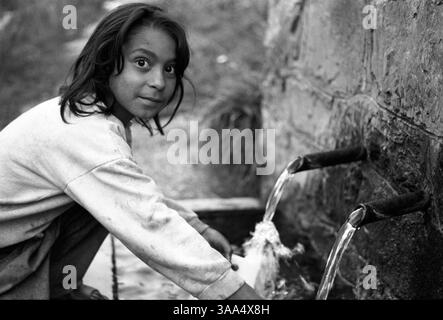 30 gennaio 2007; Ohrid-Resen, MACEDONIA; la nipote di Jamela ottiene un po' d'acqua da una sorgente naturale vicino alla discarica di Bukovo. L'acqua sotterranea nell'area è probabilmente contaminata dalle sostanze chimiche tossiche che fuoriescono dalla discarica. I rom rimangono ai margini, vendono cose nel vecchio bazar, o aspettano un lavoro sulla strada. Le persone che oggi conosciamo come rom o zingari, facevano originariamente parte di un esercito indiano reclutato tra i più bassi intoccabili lanciati dai loro governanti ariani, per respingere le successive ondate di invasori musulmani. La maggior parte dei rom vive e lavora in condizioni terribili Foto Stock