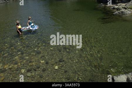 Nel caldo dell'estate le acque che scorrono lungo la South Fork del fiume Yuba vicino a Nevada City offrono la possibilità di sfuggire al caldo e godersi la serenità delle spiagge del fiume e delle tranquille piscine. La gente del posto e altre persone che conoscono la posizione di queste piscine vengono regolarmente in un pomeriggio di relax. Cindy Redmond se ne andò e la sua amica Cindy Hoffman a destra, guardò e galleggiò una piccola zuppa di beni di prima necessità attraverso il fiume verso una spiaggia sabbiosa vicino a Edwards Crossing, giovedì 12 luglio 2001. Sacramento Bee/Jay Mather The Sacramento Bee/ZUMA Press Foto Stock
