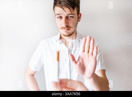 Il giovane rifiuta una sigaretta isolata sullo sfondo bianco Foto Stock