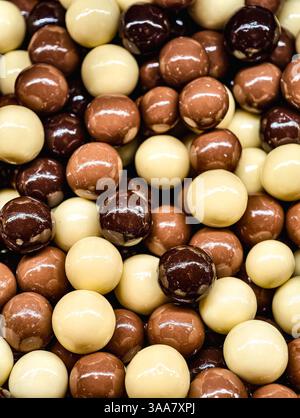 Cubetti di caramello ricoperti di cioccolato assortiti, cioccolato fondente, latte e cioccolato bianco, dolcetto Macro Fotografia delizioso dessert snack per bambini e adulti cibo per feste, vivace sfondo di pasticceria Foto Stock