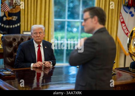 Washington, Stati Uniti. 26 marzo 2025. U. Il presidente Donald Trump, parla con il presidente della camera Mike Johnson, R-LA, giusto, prima di firmare un ordine esecutivo che aumenta le tariffe su tutti i veicoli importati presso l'Ufficio ovale della Casa Bianca, 26 marzo 2025 a Washington, D.C. credito: Daniel Torok/White House Photo/Alamy Live News Foto Stock