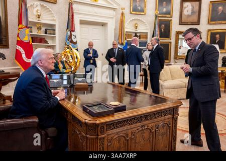 Washington, Stati Uniti. 26 marzo 2025. U. Il presidente Donald Trump, parla con il presidente della camera Mike Johnson, R-LA, giusto, prima di firmare un ordine esecutivo che aumenta le tariffe su tutti i veicoli importati presso l'Ufficio ovale della Casa Bianca, 26 marzo 2025 a Washington, D.C. credito: Molly Riley/White House Photo/Alamy Live News Foto Stock
