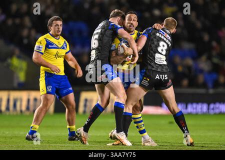 WARRINGTON, INGHILTERRA - 28 MARZO 2025: Paul Vaughan dei Warrington Wolves viene affrontato da Morgan Gannon e Mikolaj Oledzki dei Leeds Rhinos durante la puntata Foto Stock