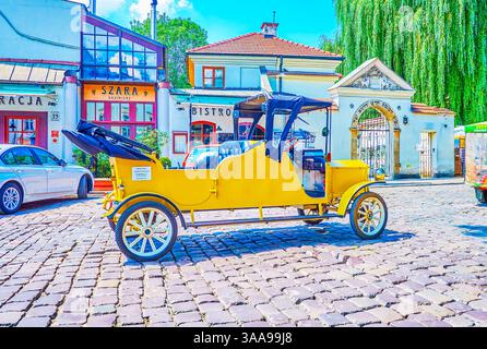 Cracovia in Polonia - Giugno 21, 2018: La scenic giallo in stile retrò auto elettrica serve come il trasporto turistico nella città vecchia di Cracovia, il 21 giugno a Krako Foto Stock