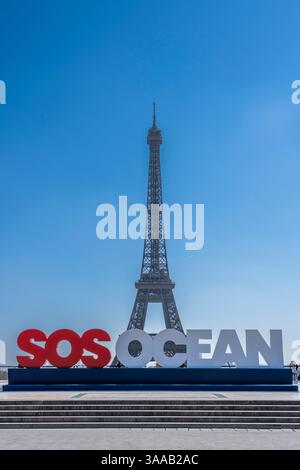 Parigi, Francia - 03 31 2025: Vista della Torre Eiffel, dell'Esplanade del Trocadero e dello slogan dell'oceano SOS e delle persone intorno Foto Stock