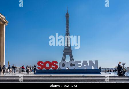 Parigi, Francia - 03 31 2025: Vista della Torre Eiffel, dell'Esplanade del Trocadero e dello slogan dell'oceano SOS e delle persone intorno Foto Stock