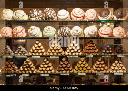 Un'esposizione di molti tipi diversi di pasticcini, tra cui cupcake e ciambelle. Ci sono almeno 15 diversi tipi di pasticcini in esposizione Foto Stock